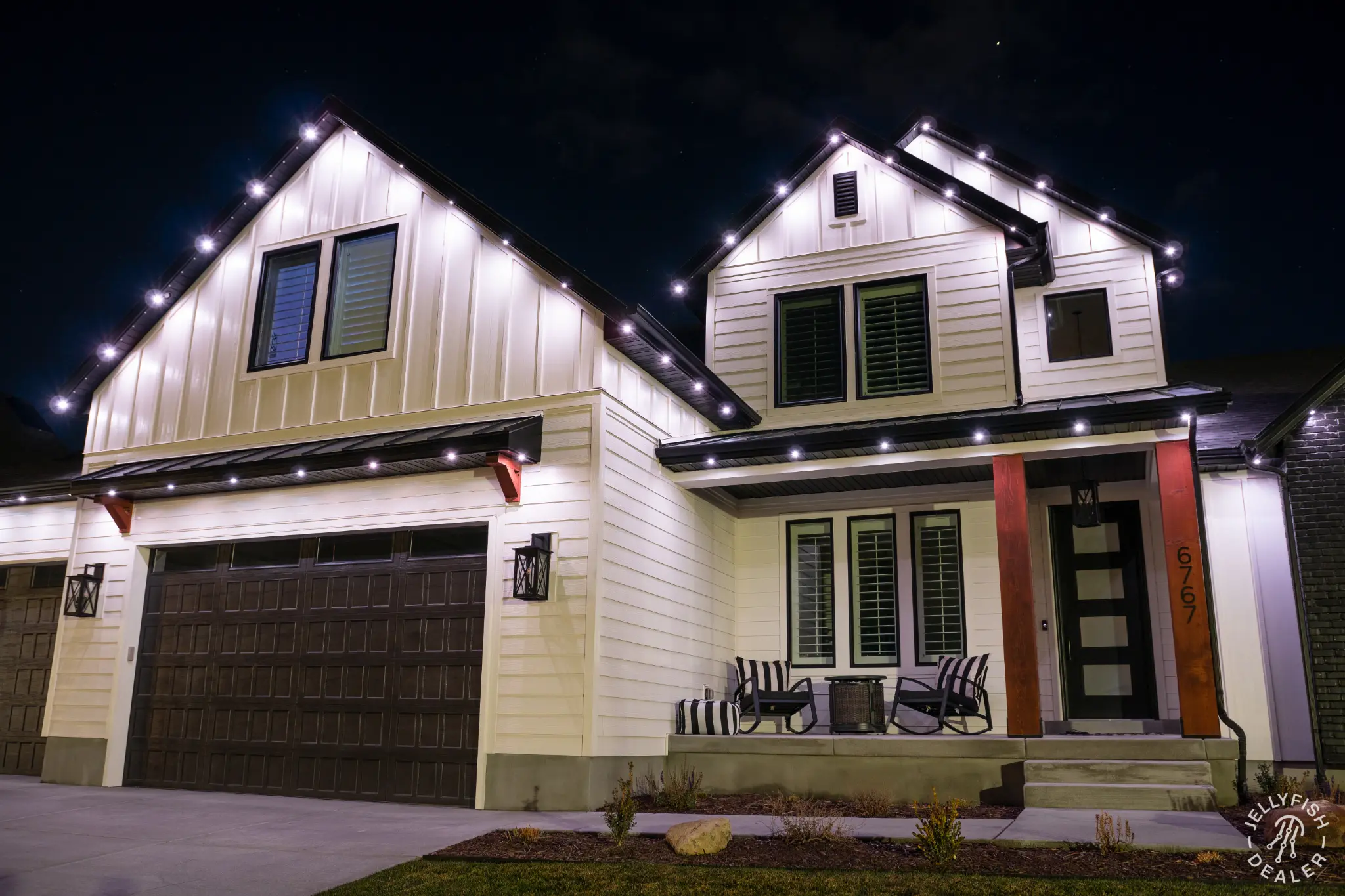 Home roofline illuminated in warm-white permanent outdoor lighting at night