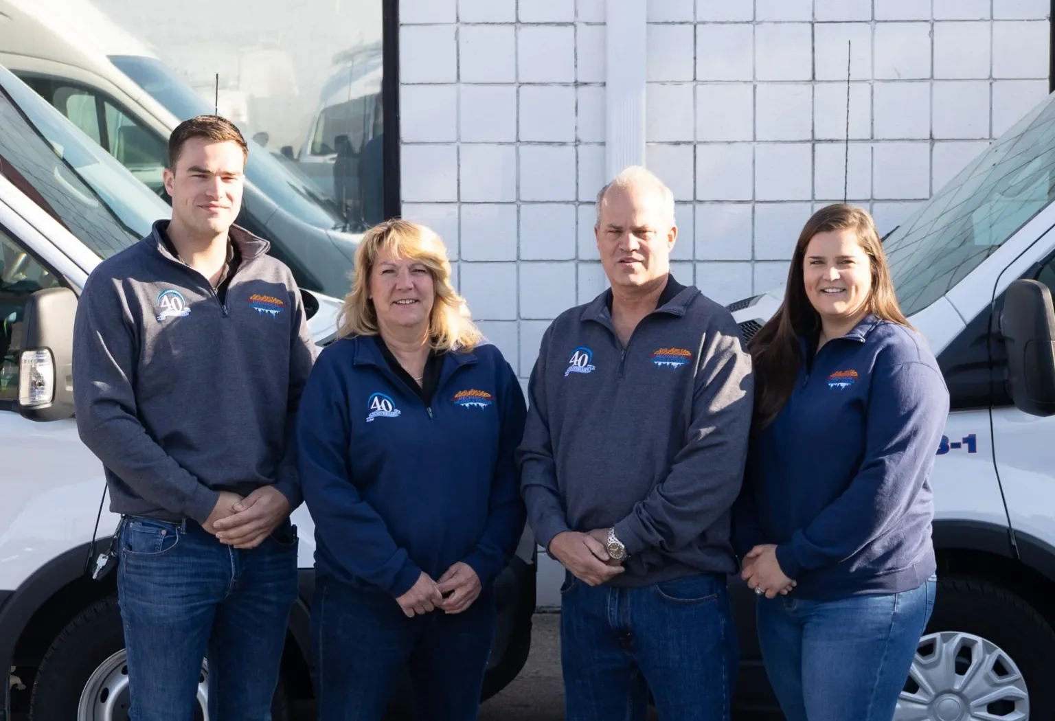 Mechanical Heating, Cooling & Electrical family members standing in front of service vans