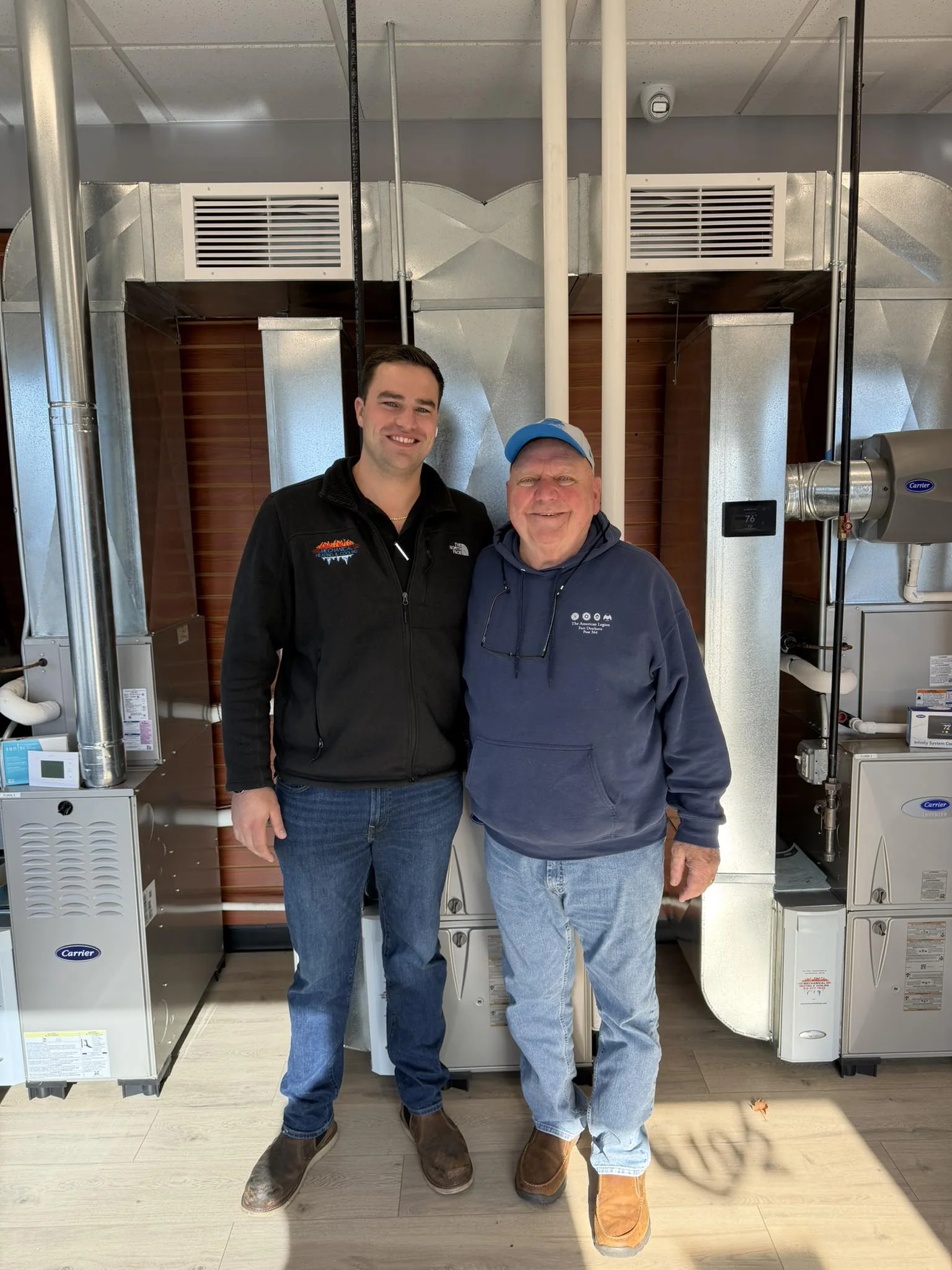 Mechanical Heating, Cooling & Electrical team members standing in front of HVAC equipment