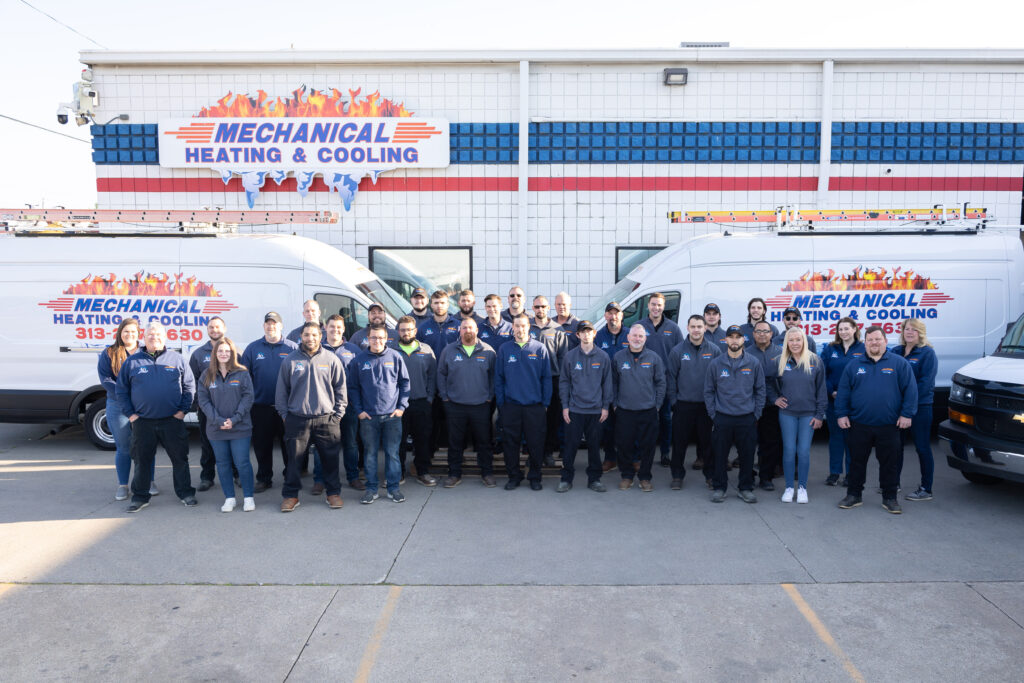 Team of Mechanical Heating & Cooling in front of service vans, showcasing HVAC professionals committed to quality heating, cooling, and ventilation services in Dearborn Heights.