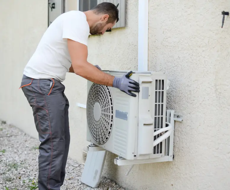Technician servicing a ductless mini-split HVAC system, ensuring efficient heating and cooling for homes in Dearborn Heights.
