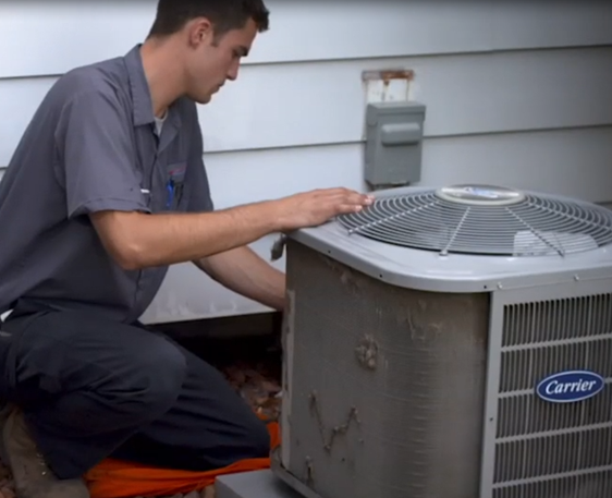 Technician performing maintenance on a Carrier HVAC unit, emphasizing residential heating and cooling services in Dearborn Heights, MI.