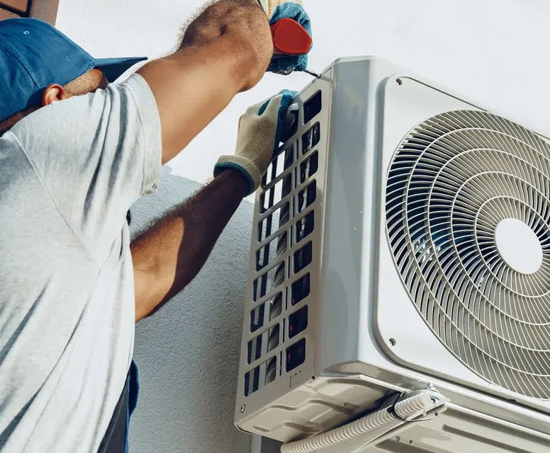 Technician installing a high-efficiency air conditioning unit, showcasing HVAC installation services for Rockwood homes.