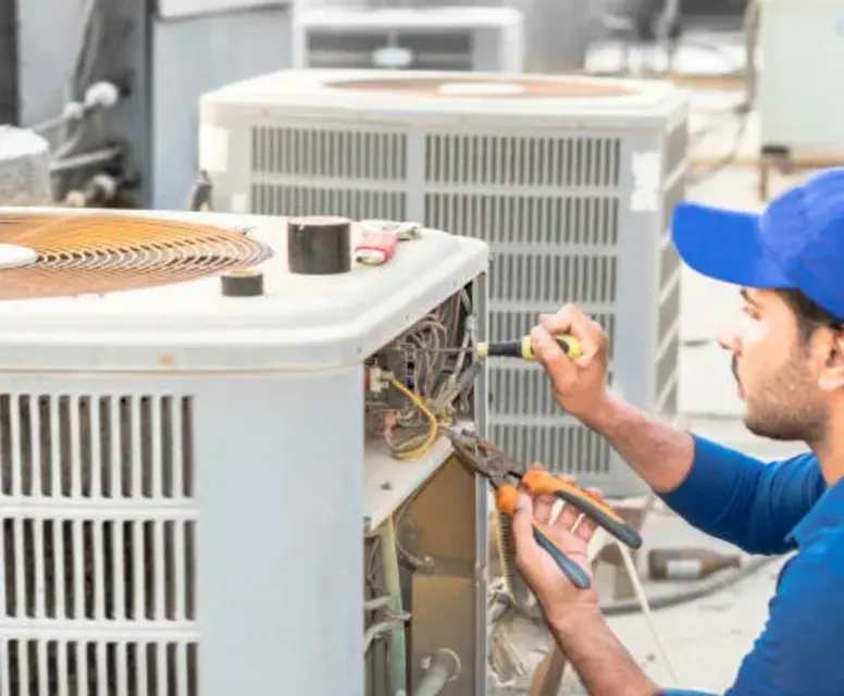 Technician performing maintenance on HVAC system, ensuring efficient operation for heating services in Canton.