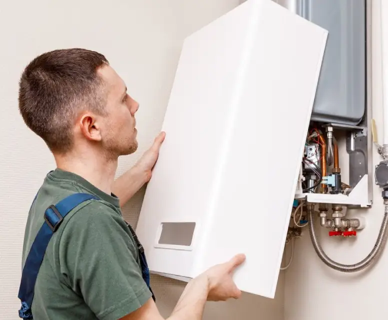 Technician installing a white heating unit, ensuring proper setup for HVAC maintenance and repair services in Ferndale, MI.