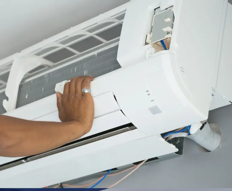 Technician servicing a wall-mounted air conditioning unit, emphasizing HVAC maintenance and repair services in Madison Heights.